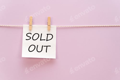 Preview: sticker with the inscription SOLD OUT hangs with a clothespin on a rope on a purple background