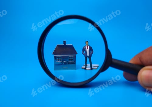 Preview: Miniature people,house keychain and magnifying glass on blue background. Real estate concept.