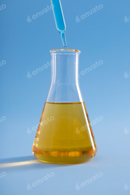 Preview: Vertical closeup of dropper with blue liquid over Erlenmeyer flask yellow liquid on blue background