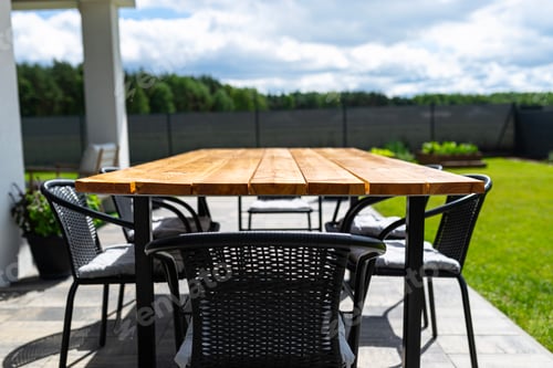 Preview: A modern table made of raw wood covered with yacht varnish, standing on the garden terrace.