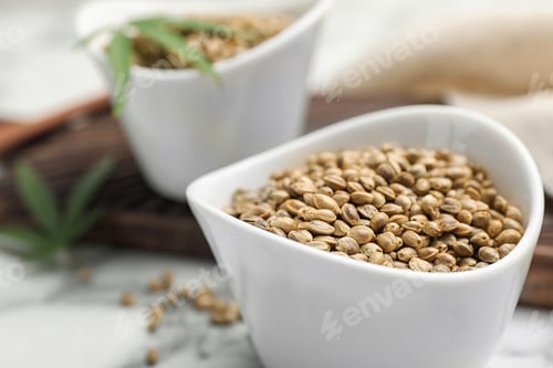Preview: Organic hemp seeds in bowl on table, closeup