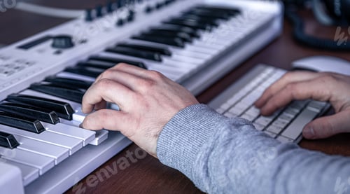 Preview: Male musician creates music using computer and keyboard, musician workplace.
