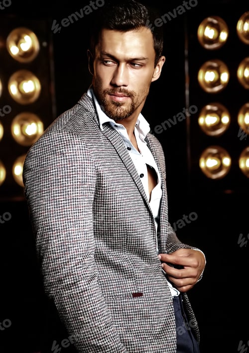 Preview: Portrait of young handsome man in suit posing in studio