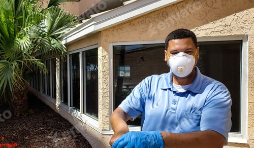 Preview: Young millennial maintenance worker don gloves and face mask doing his job.