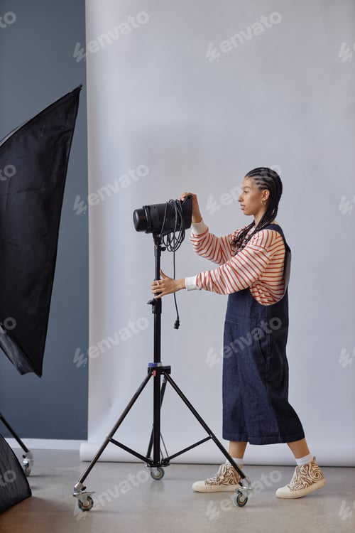 Preview: Female Photographer Setting Up Lighting Equipment
