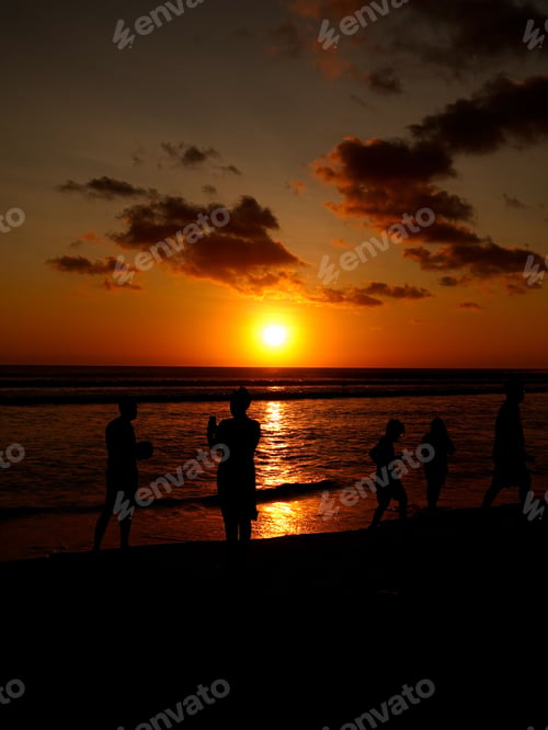 Preview: Silhouettes of people enjoying a beach sunset.