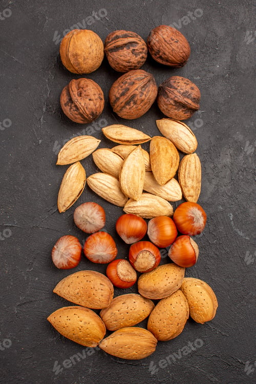 Preview: top view different fresh nuts on a dark background many nut walnut snack