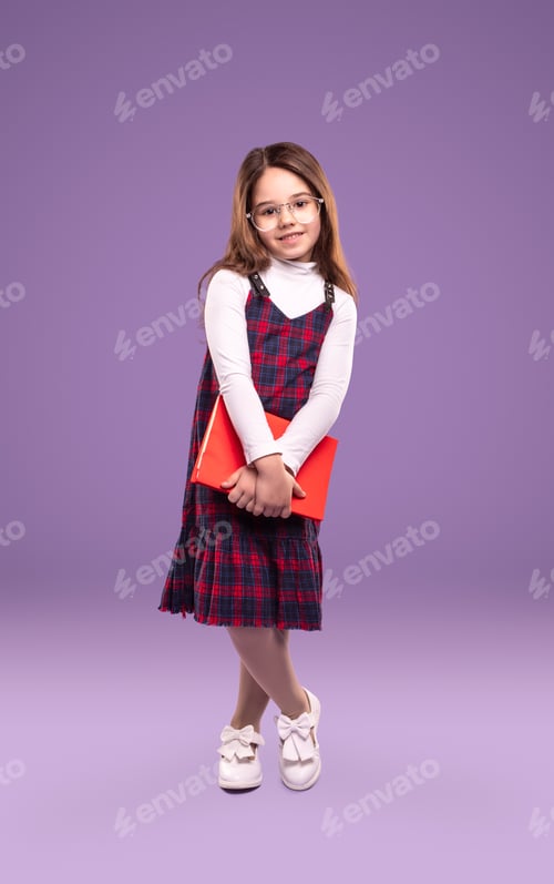 Preview: Adorable school girl with book looking at camera
