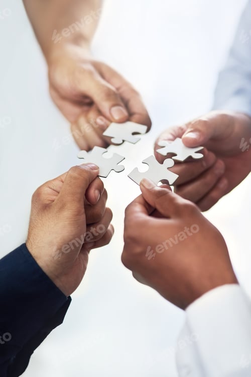 Preview: High angle shot of a group of unidentifiable businesspeople holding puzzle pieces together