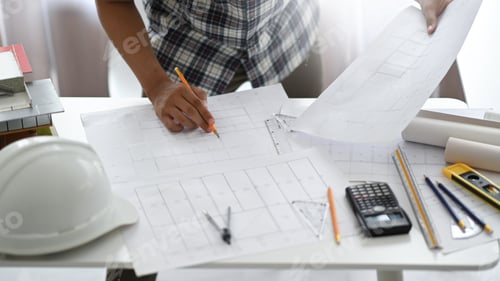 Preview: Designer man holding a pencil examining house plans, Home design architect.