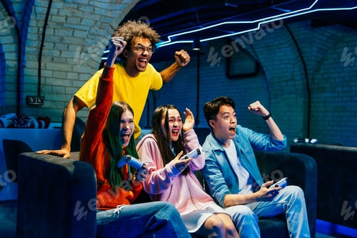 Preview: Multiethnic group of young friends playing videogames at home