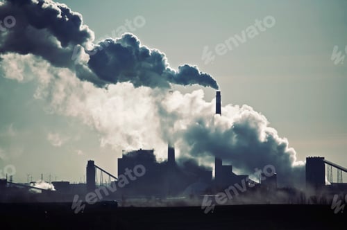 Preview: Heat, steam and smoke rising from the chimneys of a power plant against the sky.