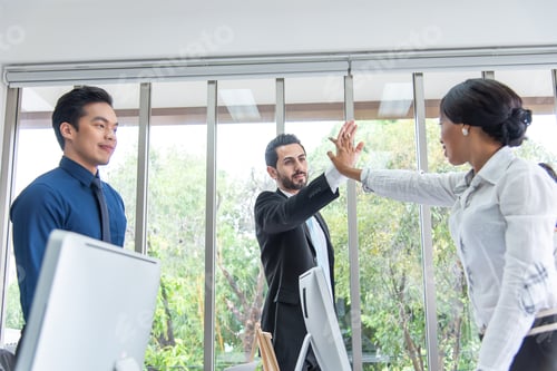 Preview: Boss hand together with businesswoman for unity,teamwork in modern office