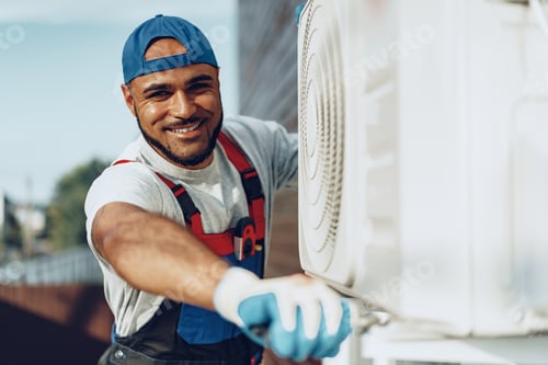 Preview: Young black man repairman checking an outside air conditioner unit