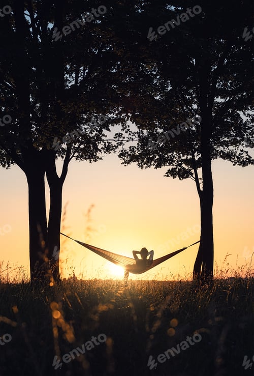 Preview: Silhouette Resting in Hammock at Sunset in Rural Area
