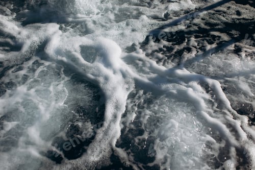 Preview: Sea foam creating patterns on dark water surface