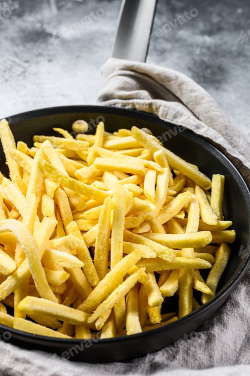 Preview: French fries in a frying pan. Gray background. Top view