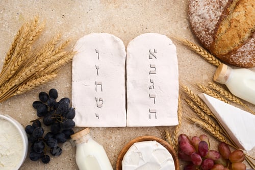 Preview: Happy Shavuot concept. Two Stones with Ten Commandments in Ancient Hebrew, Grains, milk and cheese