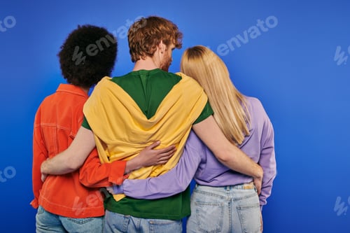 Preview: love triangle, polyamory lovers, back view of young redhead man hugging multiracial women on blue