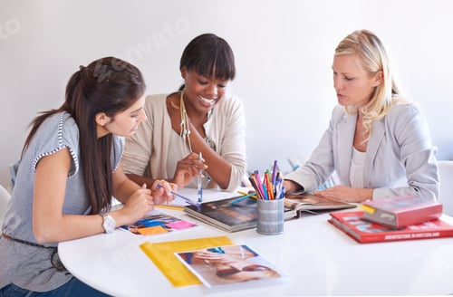Preview: Cropped shot of three businesswoman gathered around a table in the office