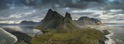 Preview: Panoramic shot of hills covered in greenery surrounded by the sea under a cloudy sky