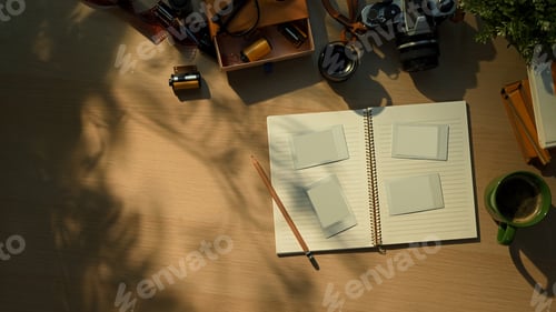 Preview: Creative workspace with vintage camera, notebook, and coffee cup in warm morning sunlight