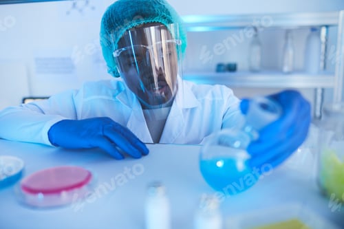 Preview: Male Scientist Looking At Liquid In Flask