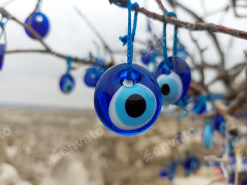 Preview: Closeup of tree with multiple blue evil eye charms hanging from it