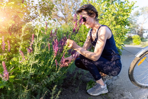Preview: Woman with Flowers Biking in a Sunny Park