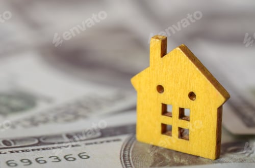 Preview: Yellow Wooden House on Dollar Bills – Concept of Real Estate Investment and Home Financing