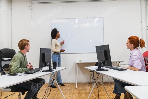 Preview: Young professionals collaborating during presentation in modern coworking space