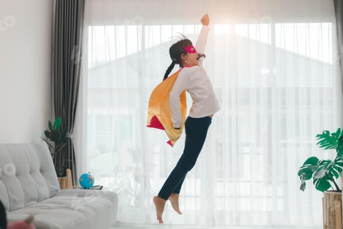 Preview: Girls child jumping on home living room couch wearing improvised superhero outfit fancy dress,