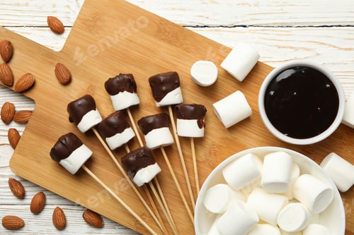Preview: Almond and marshmallow in chocolate on white wooden background, top view