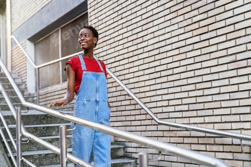 Preview: African model woman smiling and walking down the stairs of her house doorway going out to the street