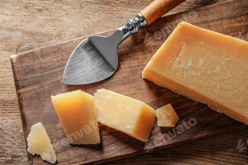 Preview: Board with cut Parmesan cheese on wooden table, top view