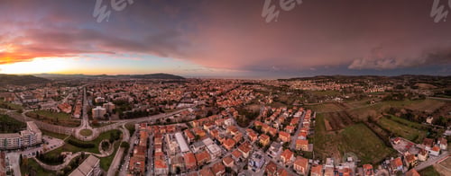 Preview: Aerial panoramic cityscape at sunset with vibrant sky.