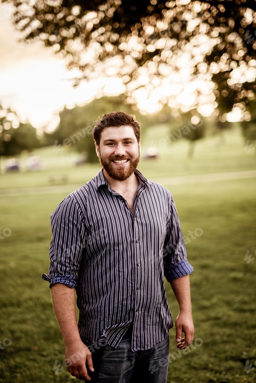 Preview: Vertical shot of a happy male smiling at the camera with a blurred background