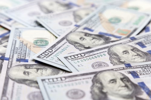 Preview: Hundred dollar bills are scattered on the table close-up soft focus