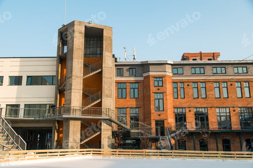 Preview: Facade of red brick building with outdoor iron stairs. Industrial building converted into offices