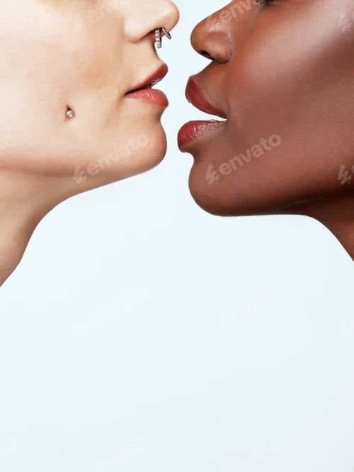 Preview: Different colours of beautiful. Studio shot of two beautiful young women against a grey background.