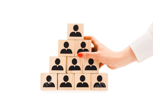 Preview: cropped view of woman holding pyramid made of wooden blocks with black human icons isolated on white