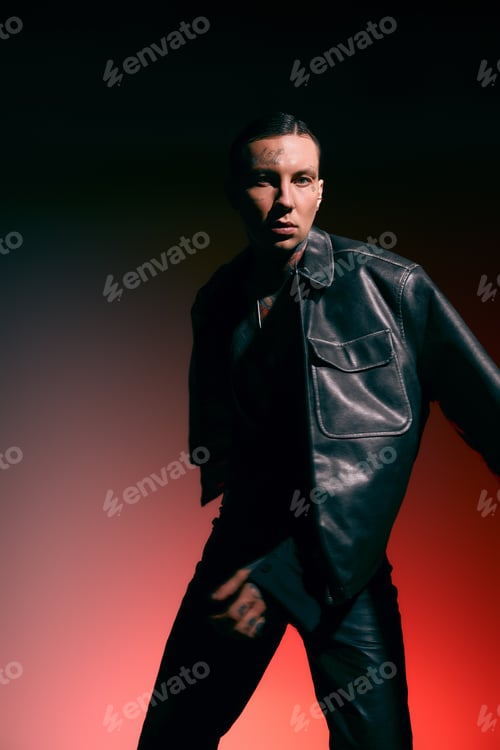 Preview: Handsome stylish man posing confidently against a vibrant background at an indoor venue