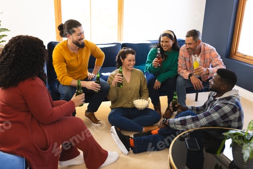 Preview: Happy diverse male and female friends talking, eating popcorn and drinking beer at home
