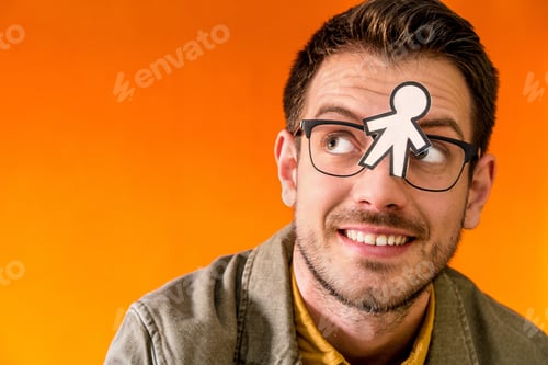 Preview: Smiling man with funny paper toy on eyeglasses