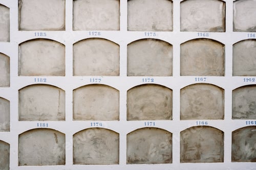 Preview: Wall of a cemetery with the holes of the niches one on top of the other covered.