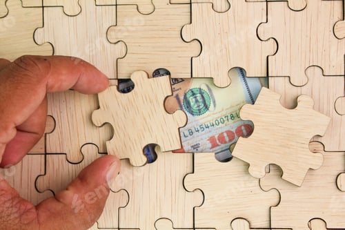 Preview: Dollar bills behind the wooden puzzle are searched for. Finance concept background