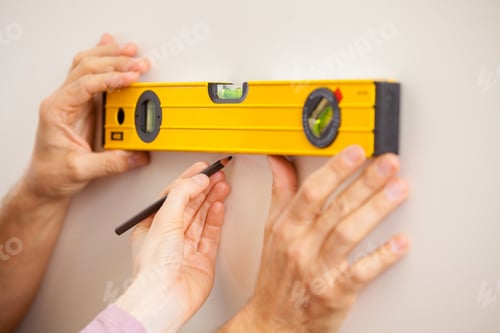 Preview: Helping hand. Close-up of two people taking wall measurements