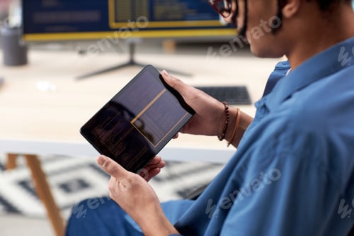 Preview: Close up of black computer programmer holding tablet