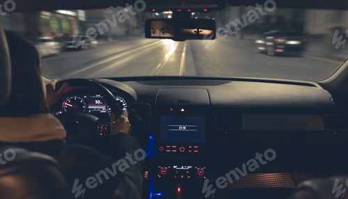 Preview: Driving a car at night, a woman driving her modern car at night in the city.