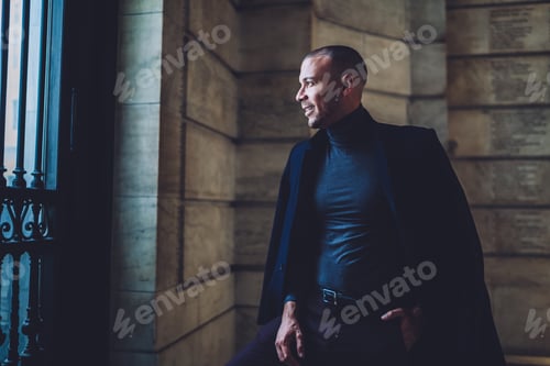 Preview: Smiling stylish man in suit looking at window with smile